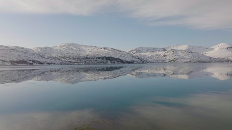snowy mountain reflections on water. Cold landscape reflex. blue reflexion clouds