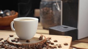 coffee pour into cup and nature steam smoke of coffee. Fresh espresso in ceramic white cup with smoke. steaming hot black coffee with froth on sauce in the morning 4K video