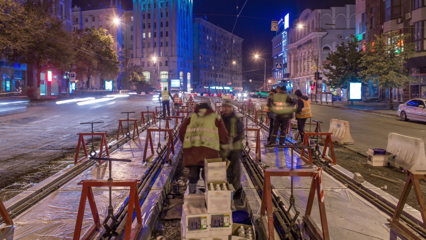 Tram rails at the stage of their installation and integration into concrete plates on the road night timelapse. Filling by liquid resin for reduction of vibration and noice. The process of