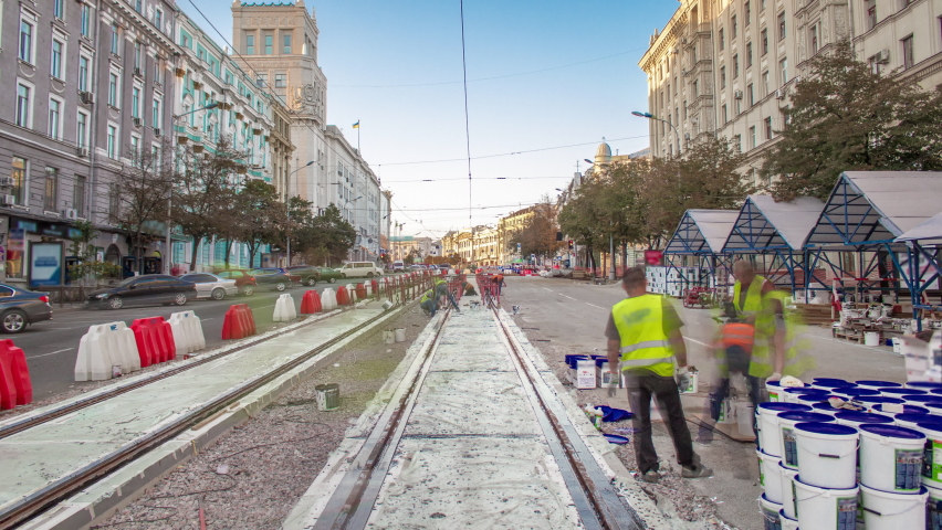 Tram rails at the stage of their integration into concrete plates on the road timelapse. Workers make mix and filling by liquid resin for reduction of vibration and noice. The process of