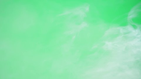 Abstract smoke on green chroma key background. Smoking, steam clouds close-up.