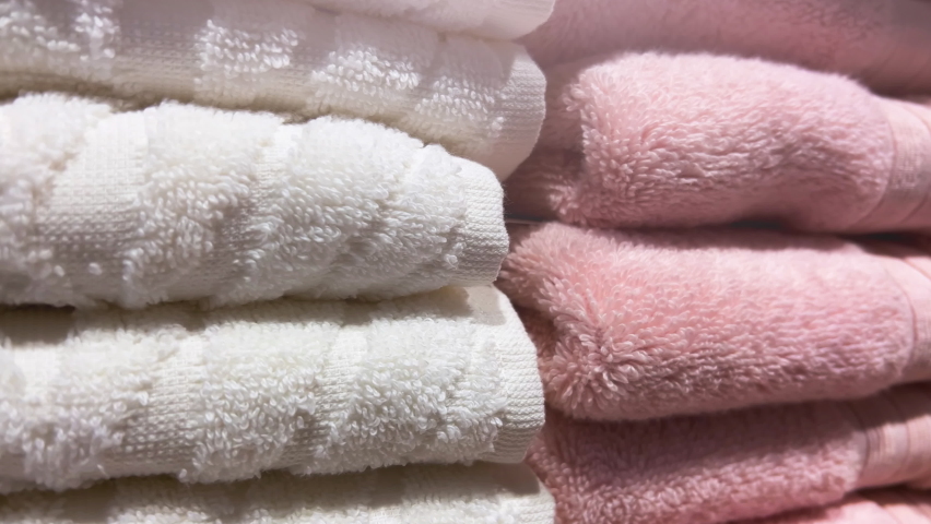 White and pink towels are stacked on store shelves. Closeup Royalty-Free Stock Footage #1089644427