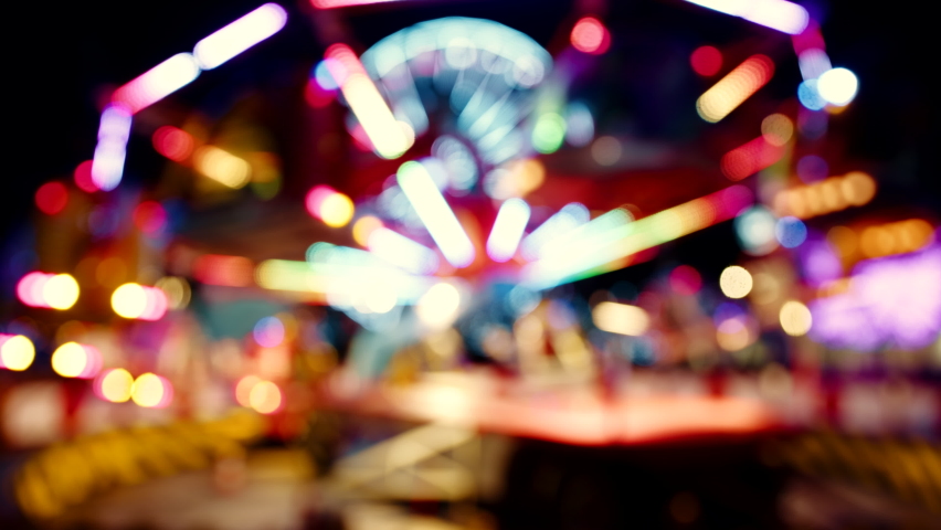 A blurred out view of a ferris wheel attraction at night in amusement park | Shutterstock HD Video #1089644875