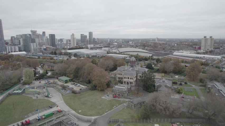 Nice historic building of Abbey Mills Pumping Station. cityscape with downtown skyscrapers in distance. London, UK.