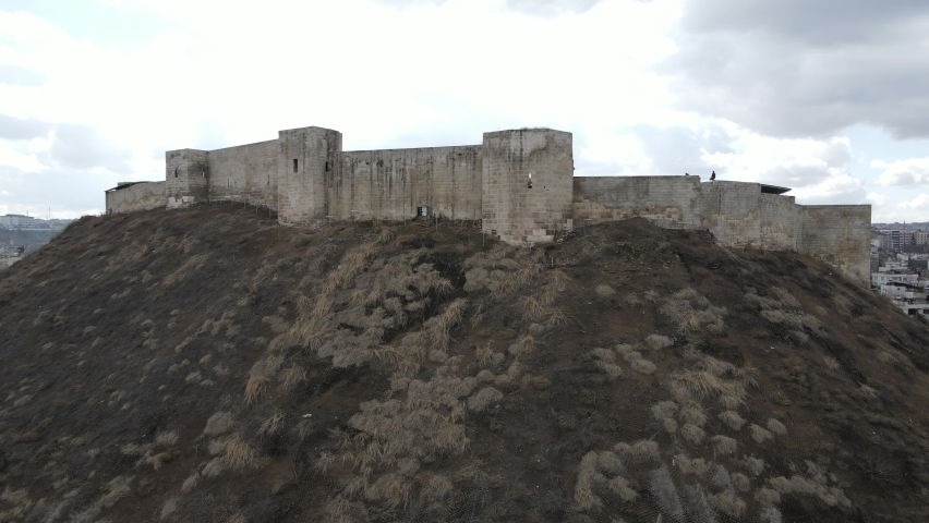 Drone view of the historical castle made of stone in Gaziantep, very large Turkish castle with castle walls and towers, historical castle built on a hill