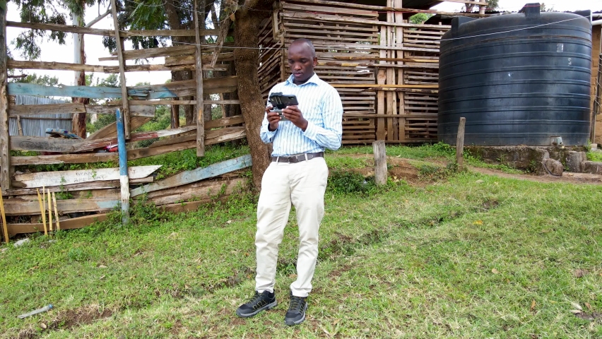 An African drone pilot operating drone in rural Africa.