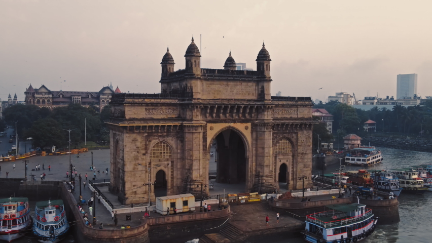 Aerial view of Gateway of India. Cityscape of old Mumbai town. Early morning weather on the seashore of Mumbai. Drone view of Taj Palace Hotel. Fishings boats sail in the sea during sunrise. Royalty-Free Stock Footage #1089648129