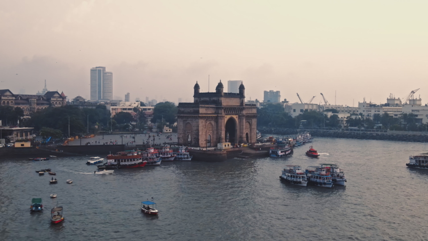 Aerial view of Gateway of India. Cityscape of old Mumbai town. Early morning weather on the seashore of Mumbai. Drone view of Taj Palace Hotel. Fishings boats sail in the sea during sunrise. | Shutterstock HD Video #1089648131