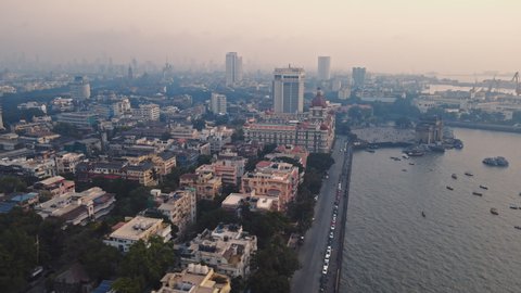 Aerial view of Gateway of India. Cityscape of old Mumbai town. Early morning weather on the seashore of Mumbai. Drone view of Taj Mahal Palace Hotel. Fishings boats sail in the sea during sunrise.