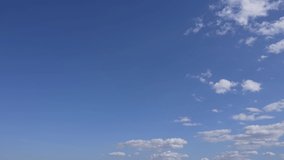 Beautiful morning sunny clear blue sky with small fluffy white clouds flying overhead in clear blue sky background. 4k video time lapse of cloudy sunny peaceful blue sky. Natural abstract background
