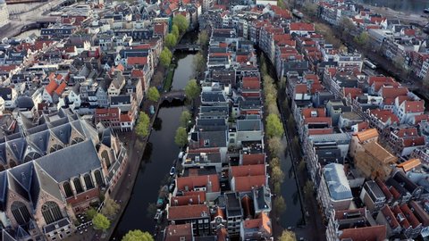 Amsterdam, Netherlands: drone flight along narrow canal in the red light district on cloudy morning
