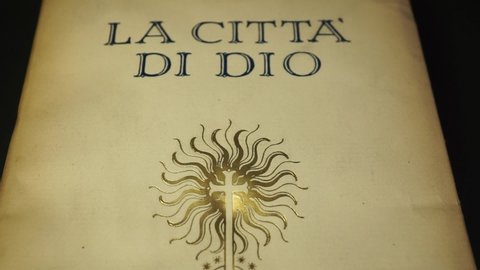 Rome, Italy - April 16, 2022, detail of the cover of an ancient book, The City of God by the philosopher Aurelio Agostino d'Ippona who entered history as Saint Augustine.