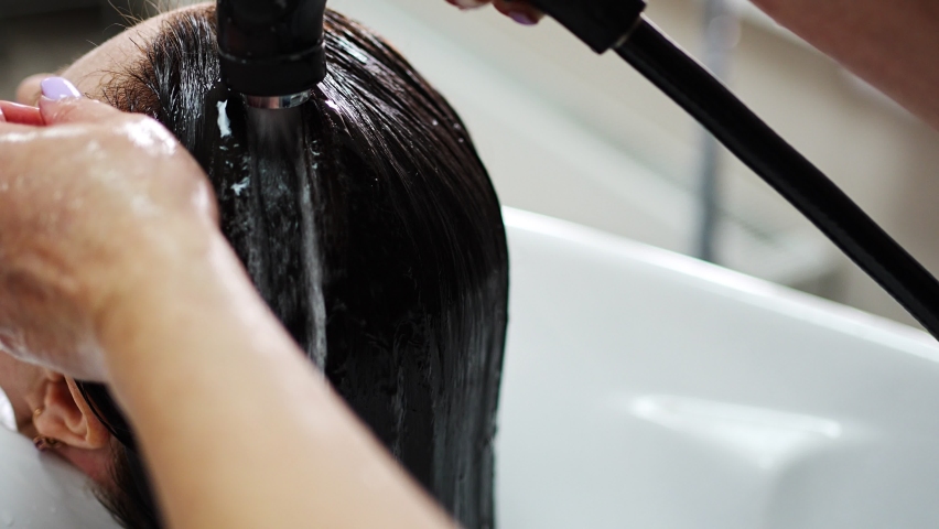 Close up view of washing hair in sink in beauty salon. High quality 4k footage
