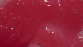 Wax cream cosmetic background video. Pink sticky balm, sweet toothpaste for children, gel. Red tooth paste texture spreading by spatula footage. 