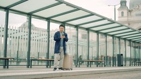 Senior Chinese tourist uses mobile phone app to book accommodation and call taxi, man near airport with suitcase. Asian man using smartphone app to rent a car at the bus stop. waiting public transport - Powered by Shutterstock - Get 15% off with code: PIKWIZARD15
