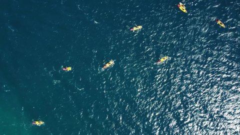 Drone aerial view of kayakers on a blue ocean sea waters.