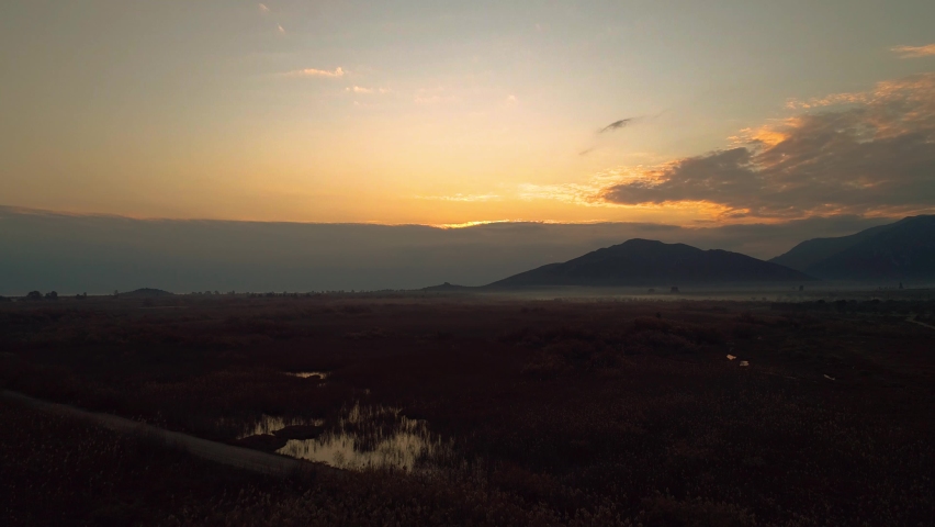 Lake Reflactions, birds fly over the lake, sunset colors with fog, sun with clouds and lake landscape, aerial footage with drone shots