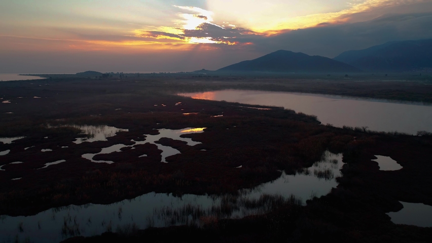 Lake Reflactions, birds fly over the lake, sunset colors with fog, sun with clouds and lake landscape, aerial footage with drone shots Royalty-Free Stock Footage #1089662903