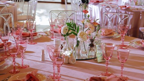 A beautiful festive table with glasses, plates and a sign with the table number. Smooth camera movement