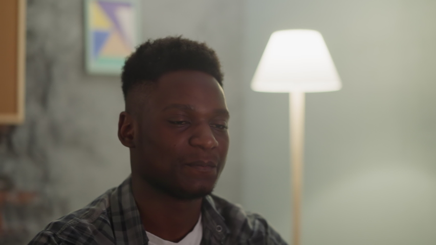 Nervous young people watch complicated football match via TV sitting in living room slow motion. Sports fans follow favorite team performance in evening