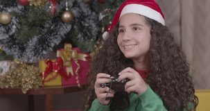 Caucasian brazilian girl, curly hair, christmas clothes. playing video game, video game remote control, entertainment, gamer. Christmas, Merry Christmas. 4K 60fps Premium cinematic video.