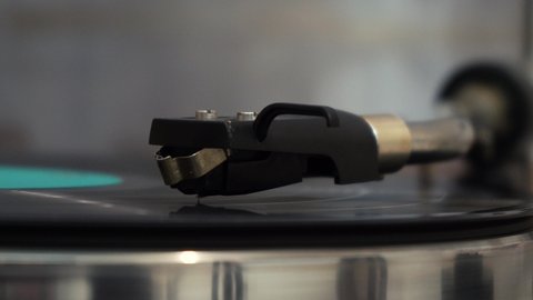 needle works on a vinyl record. The vinyl record is spinning. Needle playing on a vintage vinyl record 4k footage
