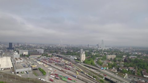 Aerial view of City of Basel with highway and railway track field on a blue cloudy spring day. Movie shot April 27th, 2022, Basel, Switzerland.