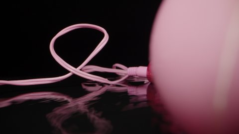 Pink vibrating balls. Sex toy, splashing water. Dolly slider extreme close-up. Laowa Probe