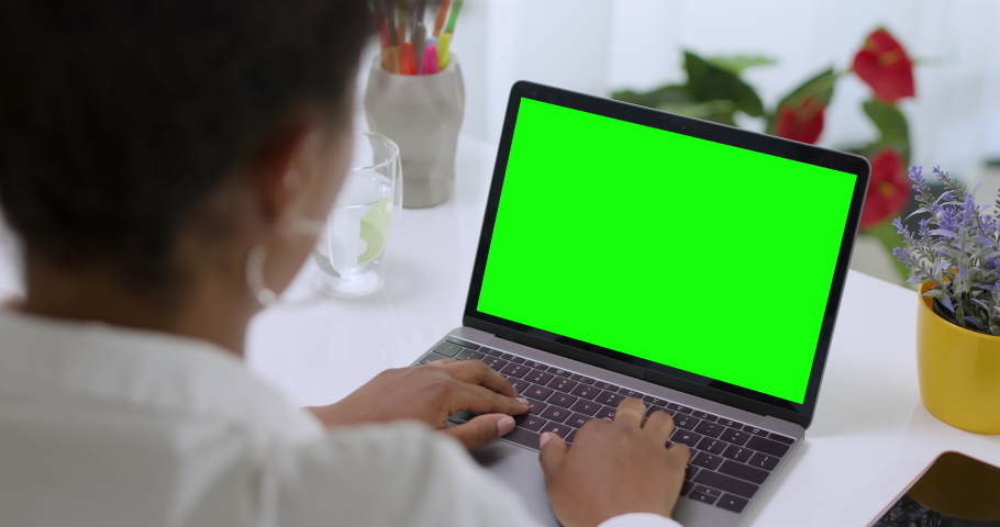 mixed race young woman typing on computer keyboard at table with