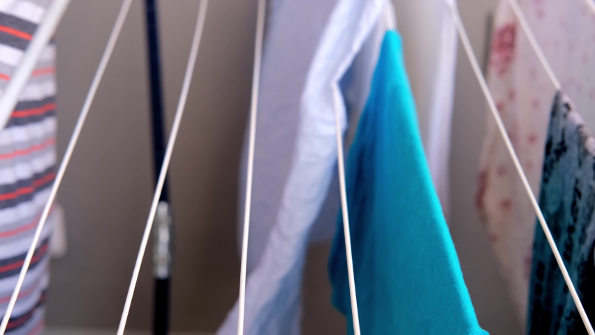 close-up female hands of middle-aged woman hanging wet washed linen on wire dryer, Aluminium Hanger For Drying Clothes, home chores concept, routine housework, selective focus Royalty-Free Stock Footage #1089670161
