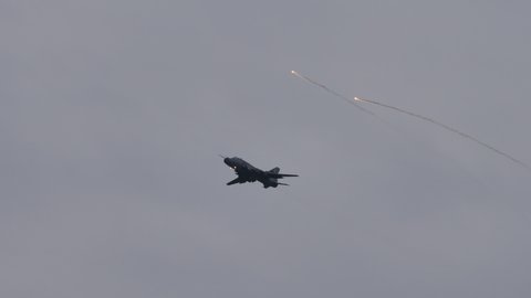 Zeltweg Austria SEPTEMBER, 6, 2019 Old fighter bomber jet aircraft low speed low altitude pass releasing flares agains heat guided missiles in grey cloudy sky. Sukhoi Su-22 Fitter of Polish Air Force