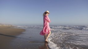Beautiful girl with straw hat enjoying sunbath at beach. Young stylish woman enjoying breeze at seaside. Carefree caucasian woman smiling with ocean waves running to the beach on motion background RED - Powered by Shutterstock - Get 15% off with code: PIKWIZARD15