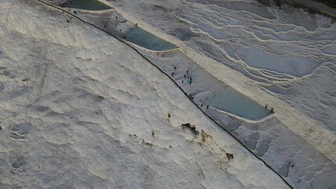 Drone view of Pamukkale travertines, natural beauty consisting of waterfalls and swimming pool with white minerals in Turkey
