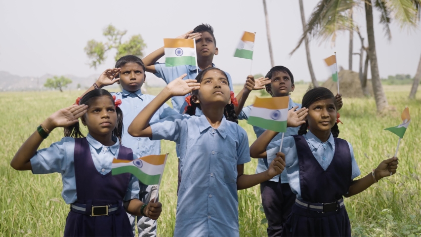 Group of village school children with Indian flag in hand saluting by looking above during flag hosting - concept of independence or republic day celebration | Shutterstock HD Video #1089682715