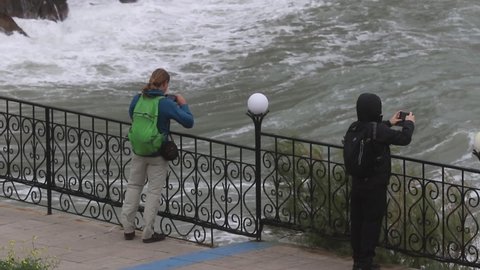 Yalta (Crimea, Crimean peninsula), 09.30.2021. People on the embankment during a storm on the Black Sea.