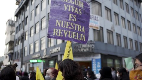 Quito , Pichincha , Ecuador - 03 08 2022: A woman is holding up a sign with a phrase in protest of the violence against women. She is marching during the International Women's day protest