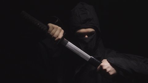 Portrait medieval warrior ninja assassin throws shuriken in smoke
