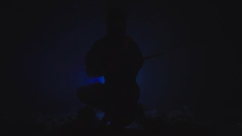 Asian night ninja warrior silhouette on dark background in smoke