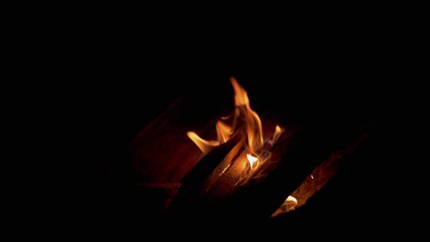 Kindling with Dry Firewood a Night Fire in the Forest. Hot tongues of flame, fire rise upward. Dry branches, sticks burn and smolder in an open bonfire. Camping. 4K. Close up.