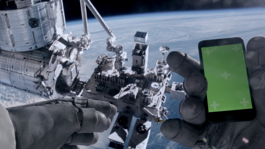 POV First person view through the astronaut helmet, astronaut using his mobile phone during the spacewalk. Green screen chroma key. ISS in the background. Some elements are furnished by NASA | Shutterstock HD Video #1089695465