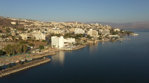 TIBERIAS, ISRAEL – DECEMBER 5 2021: Drone flight of contrast between historic landmarks and hotels in Tiberias, on the Sea of Galilee in Israel
