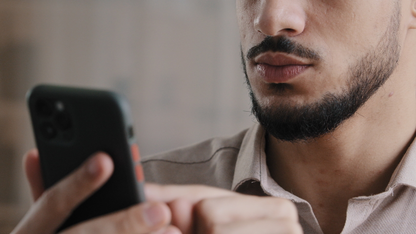 Close up male hands young hispanic arab man professional worker guy holding cellphone chatting in social networks texting message at workplace web surfing information using mobile business application Royalty-Free Stock Footage #1089696881