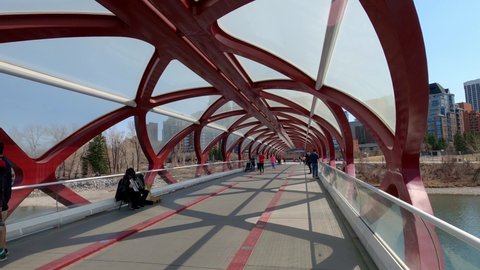 Calgary, Alberta - April 24, 2022: Pedestrians enjoying Calgary's landmark footbridge in downtown path system. 