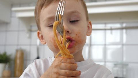 Cute preschool boy eating pasta with tomato sauce. A healthy child eats healthy organic food. Childhood, health concept