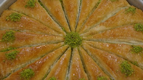 Delicious Turkish baklava with green pistachio nuts, Dessert with layered pastry, filled with chopped nuts, and sweetened with syrup or honey, Pastries of Ottoman cuisine