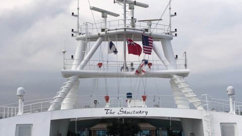 Port Everglades - 2022: Flags on Emerald Princess Cruise ship. Princess Cruises, United States, Florida, and Red Ensign or Red Duster flags. The Sanctuary enclave. Spinning marine radars.