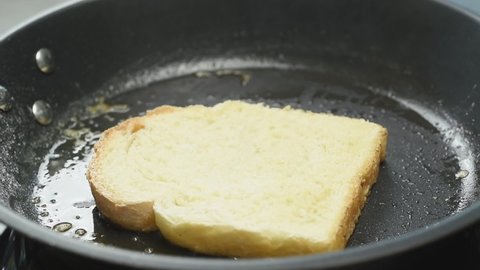 Preparation and turning of French toast in a frying pan.