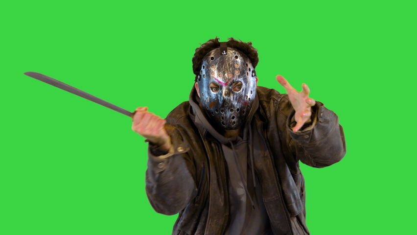 Insane maniac in metal mask with man eyes slaughter victim with machete knife Angry madman fighting on a Green Screen, Chroma Key.