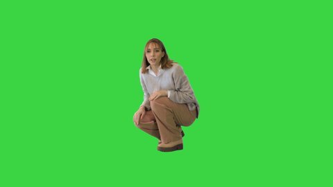 Charming girl playing and hugging with her bichon frise on a Green Screen, Chroma Key.