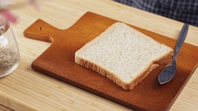 4k video, smearing cream cheese spread on slice of bread. Soft cream spreading on sourdough bread. woman using knife Spread the cream cheese on a piece of fresh bread. fat and sandwich making concept